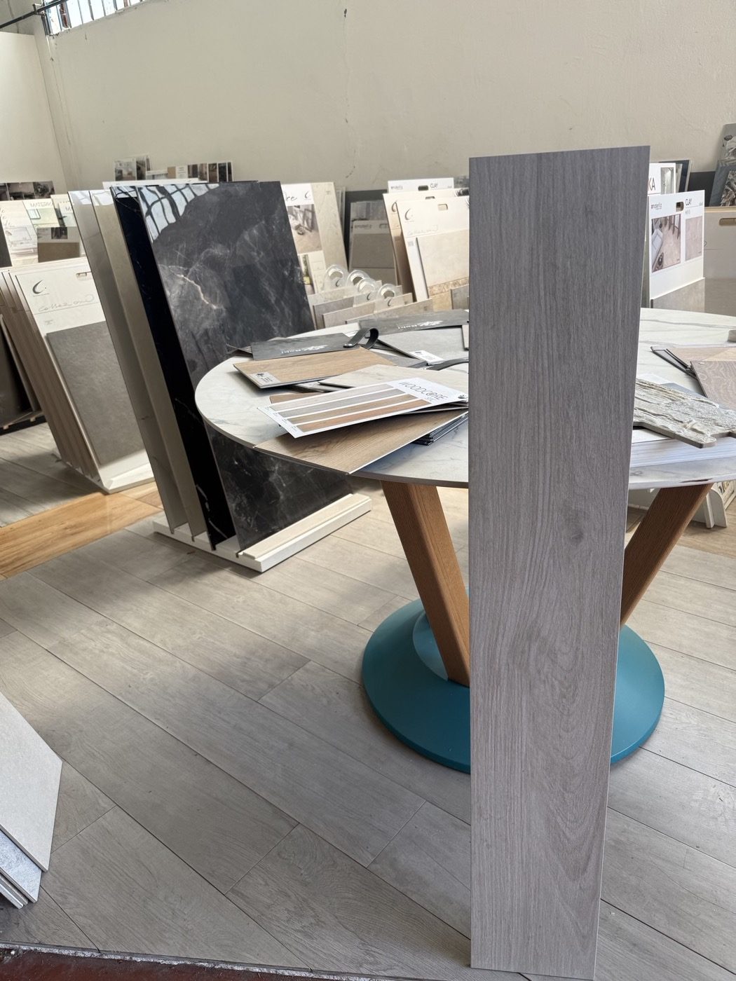 Piastrella gres effetto legno grigio chiaro su tavolo campionario